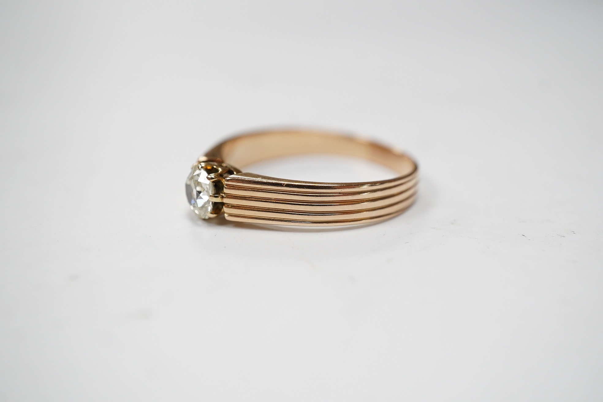 A reeded yellow metal and oval cushion cut solitaire diamond set ring, size Q/R, gross weight 2.6 grams. Condition - poor to fair